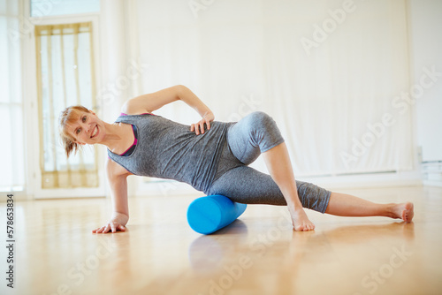 Exercise that invigorates body, mind and spirit. a woman doing roller foam exercises during a yoga workout. © Laflor/peopleimages.com