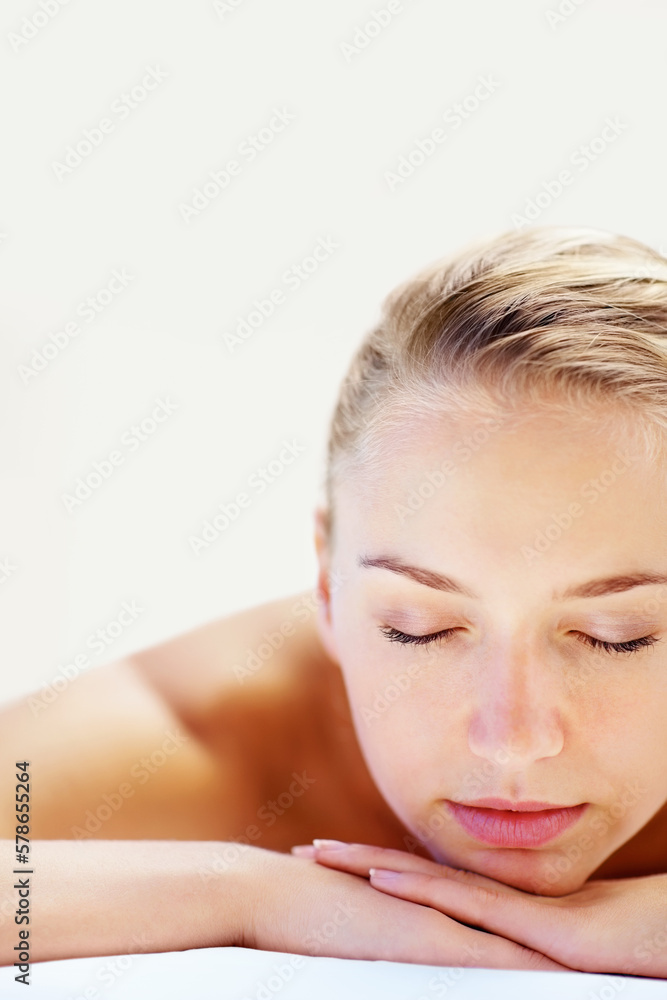 Pretty female relaxing at a dayspa , closeup. Closeup portrait of a relaxed young woman at a spa treatment.