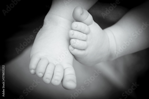 Two month old baby feet on black background