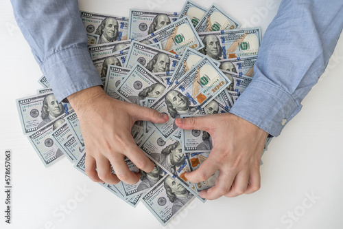 Fototapete Man's hands and a lot of dollar bills on a white table