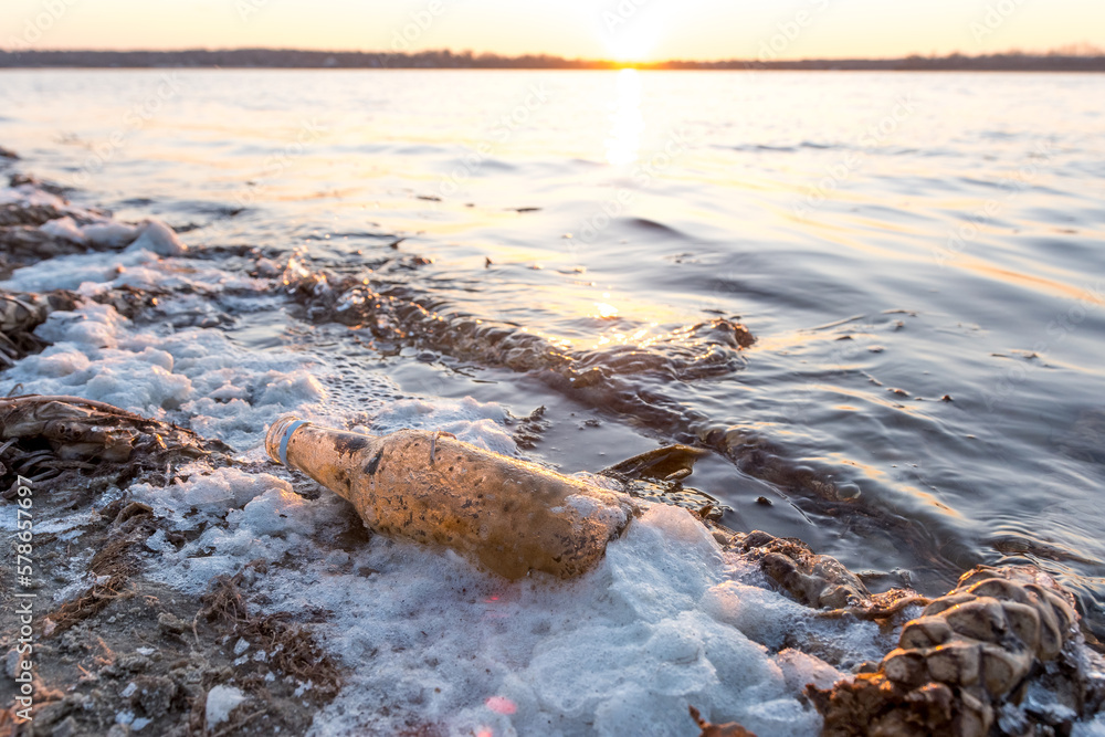 a plastic bottle on the shore of the reservoir. pollution of nature, environmental problems a plastic bottle on the shore of the reservoir. pollution of nature, environmental problems