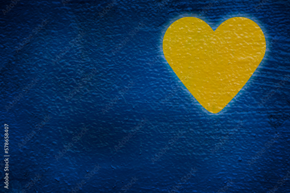 Fototapeta premium yellow heart painted on blue wall
