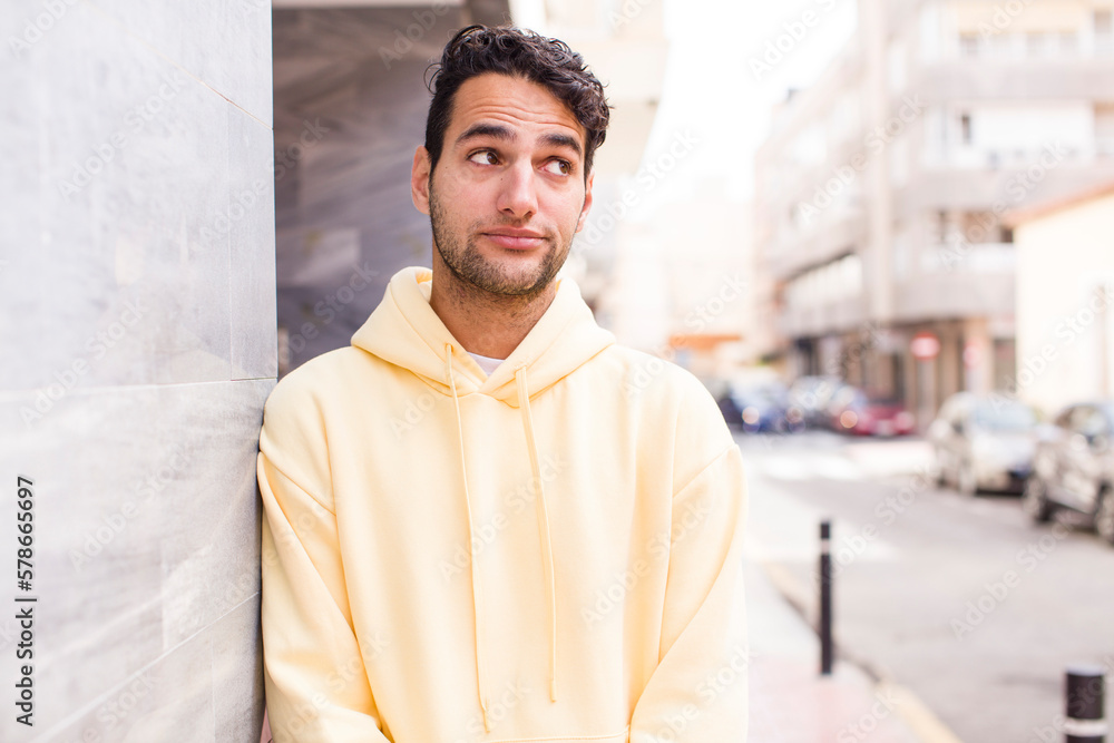 young hispanic man wondering, thinking happy thoughts and ideas, daydreaming, looking to copy space on side young hispanic man wondering, thinking happy thoughts and ideas, daydreaming, looking to copy space on side