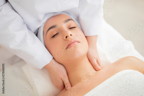 Beautician Doctor Doing Neck Massage To Young Indian Woman In Spa Salon