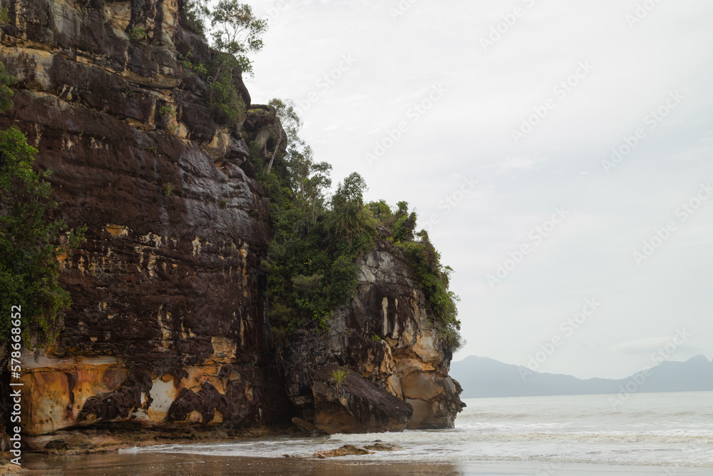 Cliff in Bako national park, overcast, cloudy day, sky and sea. Vacation, travel, tropics concept