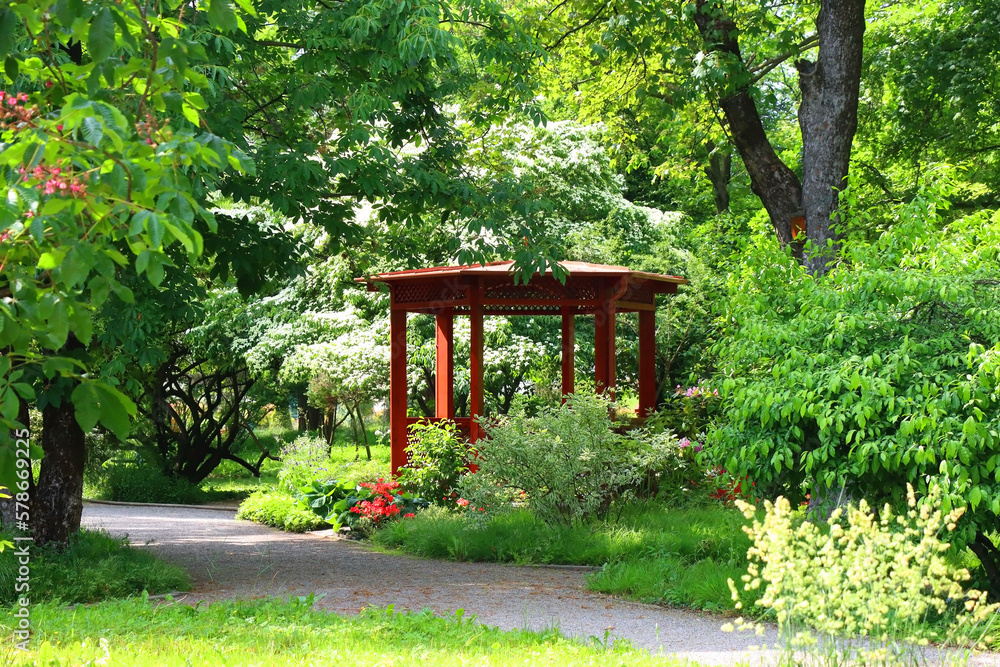 Red pavilion and lush green trees in the park. Red pavilion and lush green trees in the park.