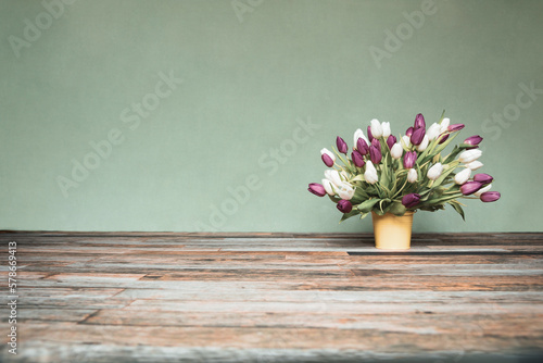 Wallpaper Mural Bouquet of tulips in a yellow bucket in front of a green wall on wooden floor Torontodigital.ca