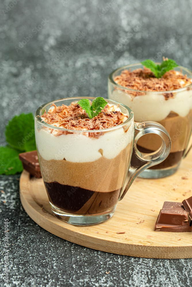 Mousse Three chocolates in a glass decorated with mint. Layered delicious dessert Mousse Three chocolates in a glass decorated with mint. Layered delicious dessert