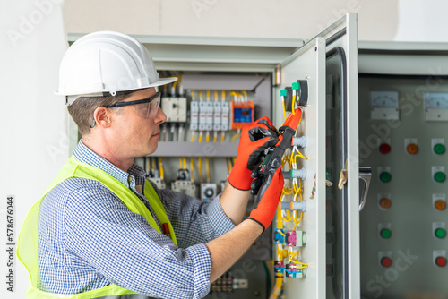 Electrician installing electrical wires and multimeter fuse switch box in hands of electrician detail photo