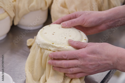 A man holds ripening cheese in special cloth. photo