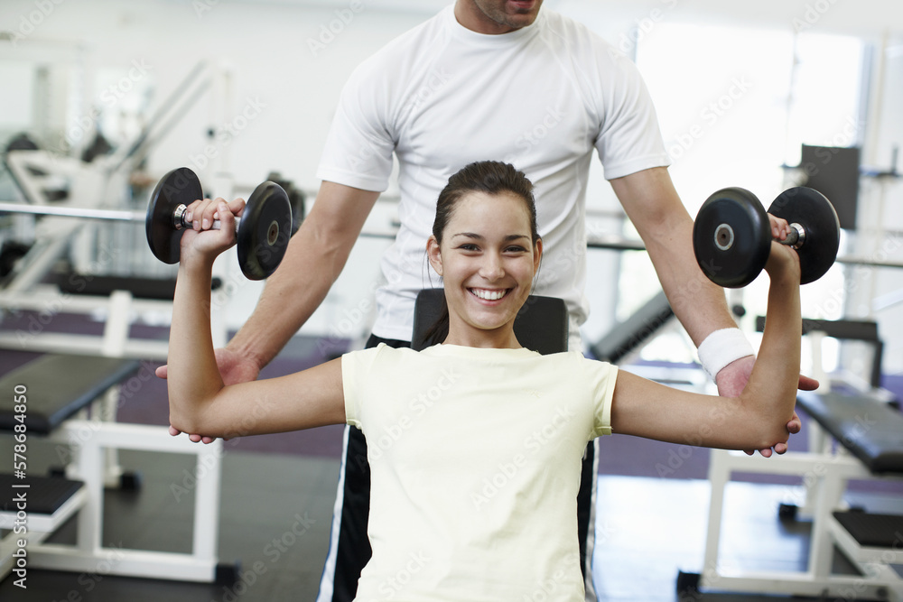 My personal trainer is great. Cropped portrait of an attractive young woman weight training with her personal trainer. My personal trainer is great. Cropped portrait of an attractive young woman weight training with her personal trainer.