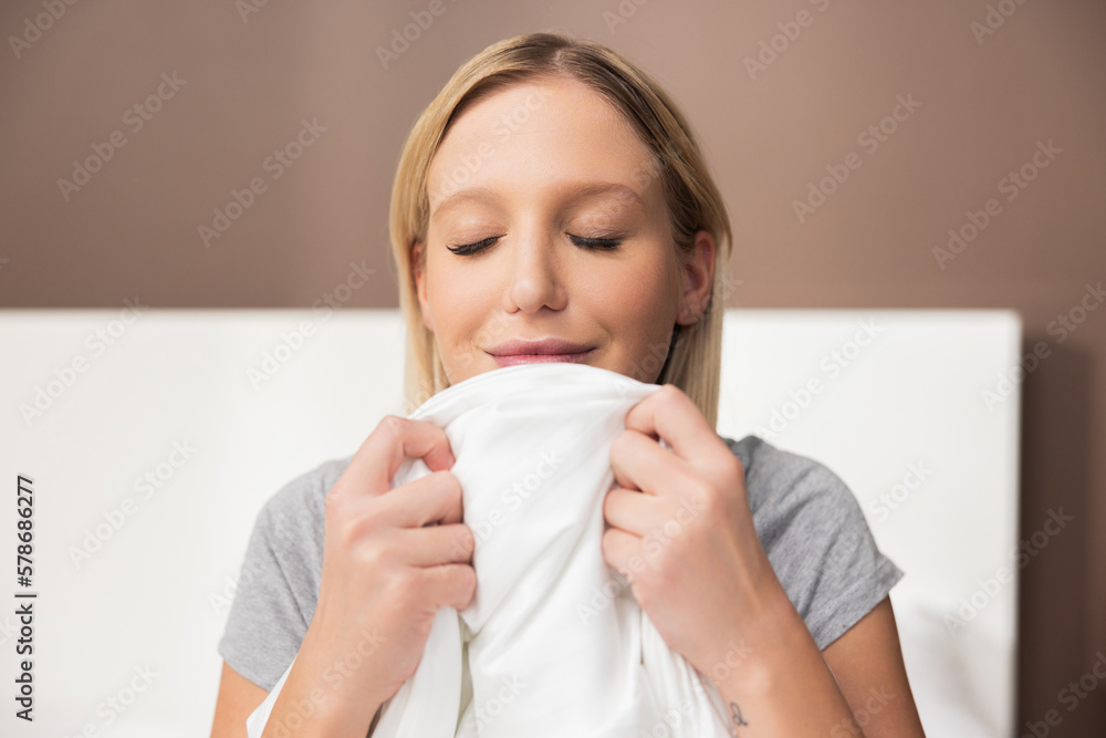 Hapy relaxed relieved blond girl lady woman wearing pajama sniffing fresh new pillow waking up after good dream night dream. Hapy relaxed relieved blond girl lady woman wearing pajama sniffing fresh new pillow waking up after good dream night dream.