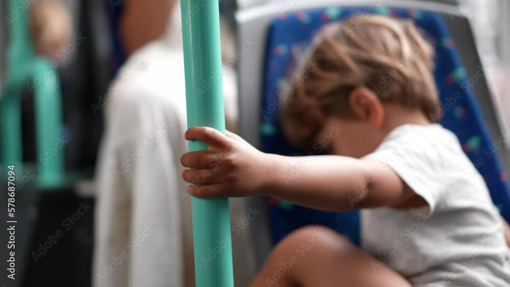 Child hand closeup holding into metal bar inside bus tram transportation. One small boy passenger traveling in city public vehicle Child hand closeup holding into metal bar inside bus tram transportation. One small boy passenger traveling in city public vehicle
