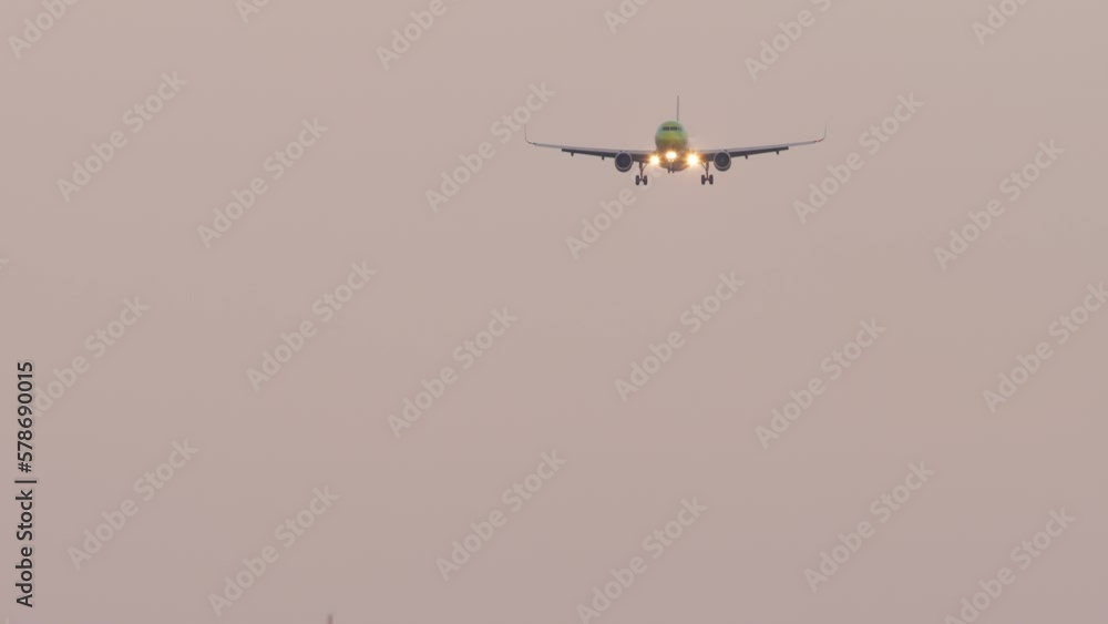 Long shot of a jet plane approaching to landing. Airplane descent, sunset or dawn Long shot of a jet plane approaching to landing. Airplane descent, sunset or dawn