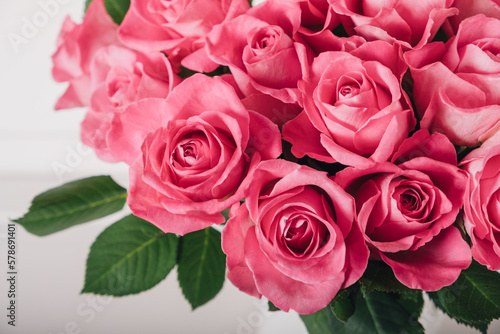 Beautiful bunch of fresh pink roses in full bloom against white background, close up. Bouquet of flowers. Valentine's day or Mother's day card.