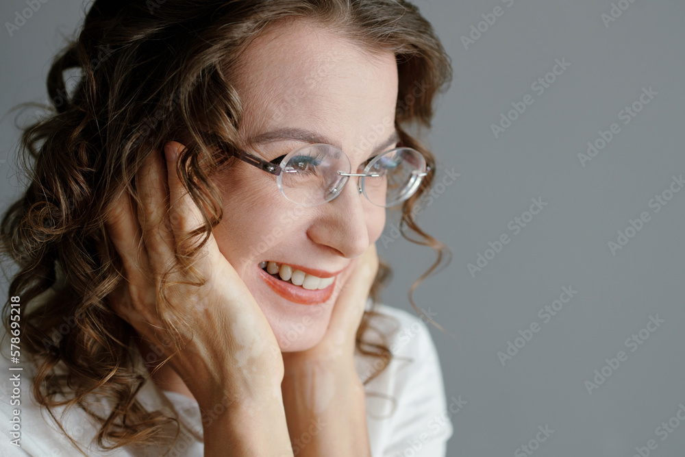 Portrait of cheerful middle-aged woman in glasses touching her face Portrait of cheerful middle-aged woman in glasses touching her face