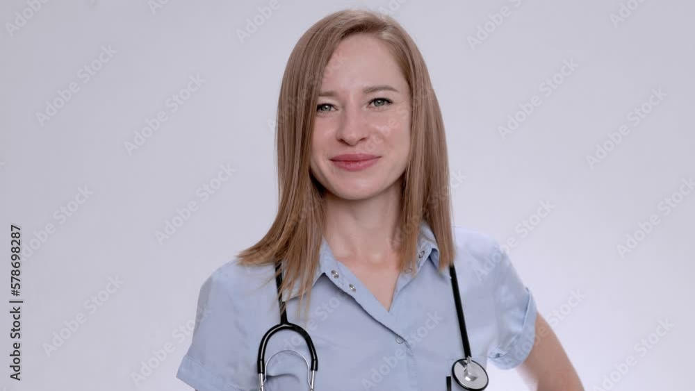 Young European female doctor in a blue medical coat and with a stethoscope. Positive close-up. Medical portrait. Young European female doctor in a blue medical coat and with a stethoscope. Positive close-up. Medical portrait.