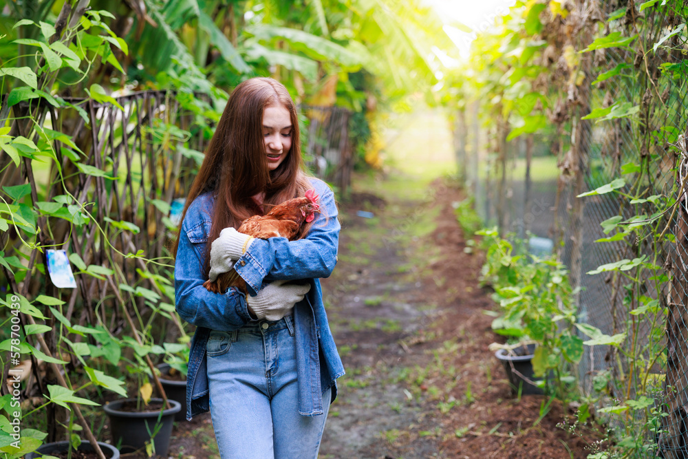 young girl farmer holding a hen in the garden young girl farmer holding a hen in the garden