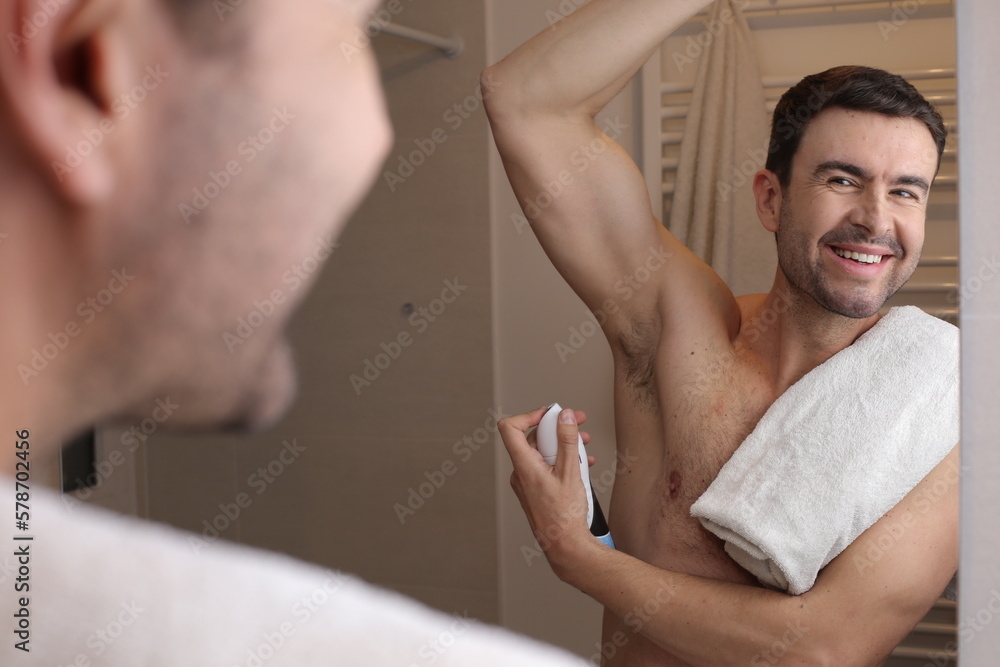 Fototapeta premium Man applying deodorant in the bathroom 