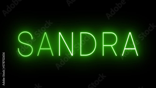 Flickering green retro style neon sign glowing against a black background photo