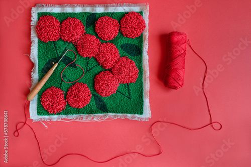 Punch needle embriodery of red flowers on green, punch needle an photo