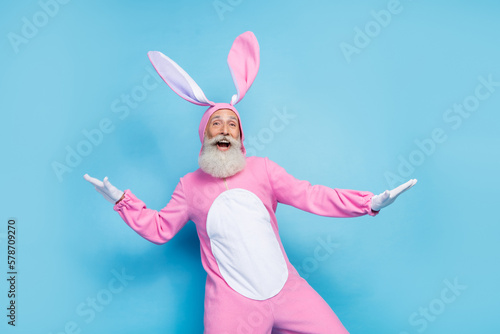 Fototapeta Photo of positive charming man pensioner dressed pink rabbit nightwear dancing s