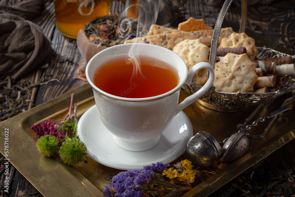 Sweet, hot tea with dry tea leaves, on an old background. Sweet, hot tea with dry tea leaves, on an old background.