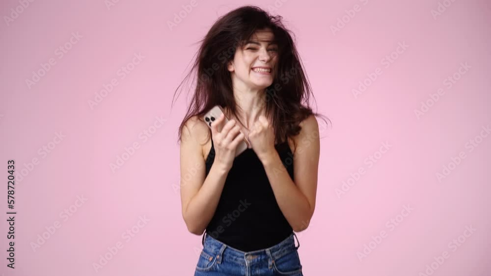 4k slow motion video of one girl who received a nice message and is happy over pink background. 4k slow motion video of one girl who received a nice message and is happy over pink background.