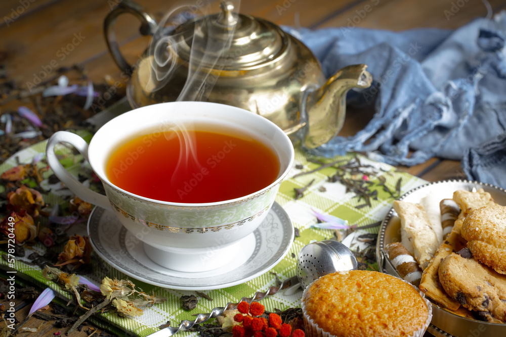 Sweet, hot tea with dry tea leaves, on an old background. Sweet, hot tea with dry tea leaves, on an old background.