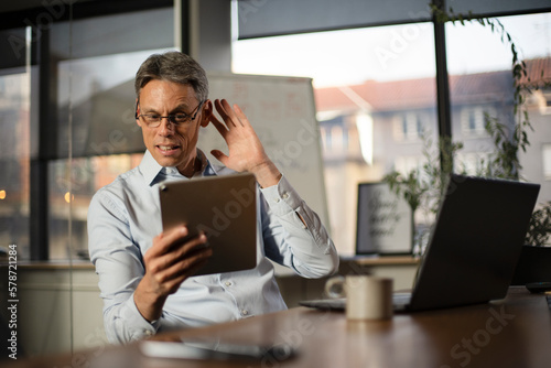 Portrait of businessman in office. Man using digital tablet. Businessman having video call..