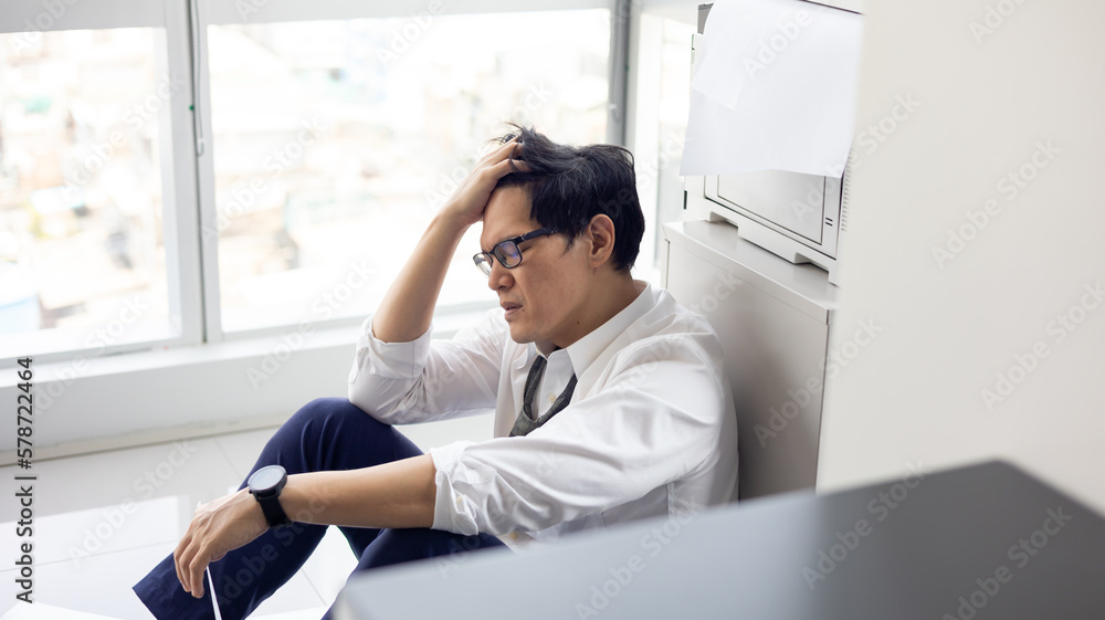Overload office worker. Alone stressed and sad  asian office worker is sitting beside error copy machine at the office.