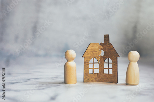 Divorce, division of property, poverty and no money concept. Wooden broken house on light background. Mortgage, rent, realtor concept copy space space for text photo