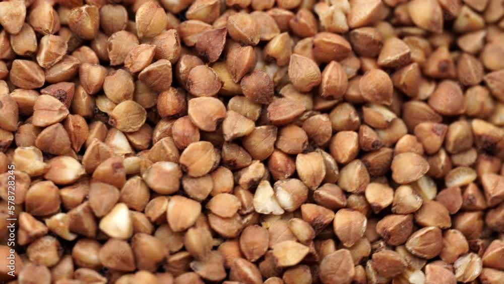 Buckwheat Groats Dry Uncooked Raw Natural Fresh Brown Rotating. Roasted buckwheat kernels. Healthy organic food. Background. Buckwheat Groats Dry Uncooked Raw Natural Fresh Brown Rotating. Roasted buckwheat kernels. Healthy organic food. Background.