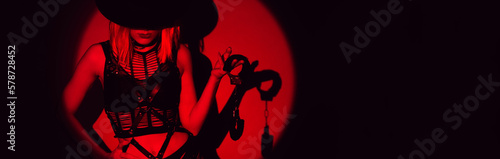 sexy slave girl in underwear and a hat holds handcuffs in hands. Concept of BDSM submissive woman. Panoramic wide horizontal photo for banner head cover