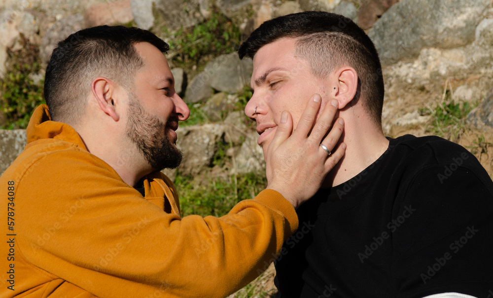 A couple of gay men smile at each other in love. Homosexuality and LGBTQ+ concept. A couple of gay men smile at each other in love. Homosexuality and LGBTQ+ concept.