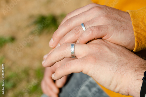 Couple of two homosexual men shaking hands with engagement rings. Concept of homosexuality, gay marriage and LGBT concept