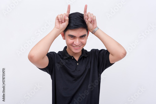 Billede på lærred A devious man makes horns with two fingers like an devil, while looking at the camera