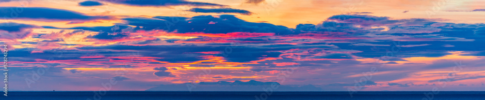 A lonely fishing ship in the ocean under an incredibly colorfully picturesque sky at sunrise. Iceland
