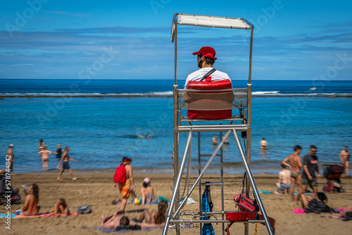 Am Stadtstrand von Las Palmas de Gran Canaria beobachtet ein Rettungsschwimmer das Treiben im Wasser 