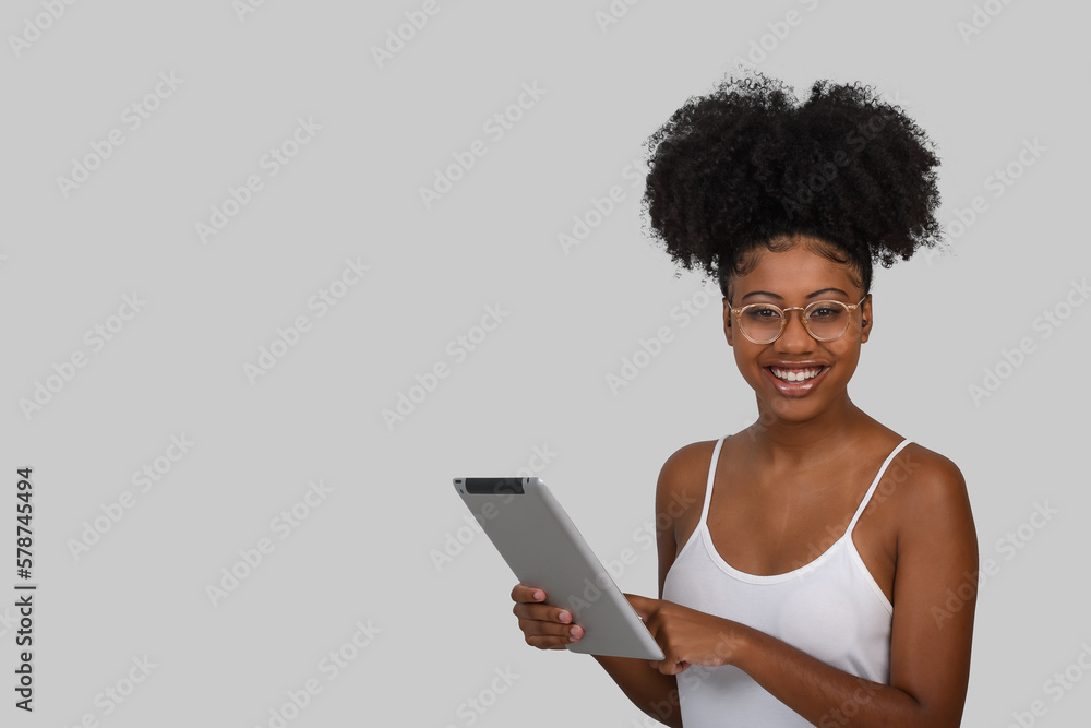 woman with a tablet computer, smiling looks at the camera on gray background woman with a tablet computer, smiling looks at the camera on gray background