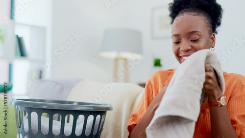 Black woman, smelling clean laundry and cleaning service with hygiene, fabric and happy person with housekeeper. House work, domestic cleaner and washing scent, female with towel and housekeeping