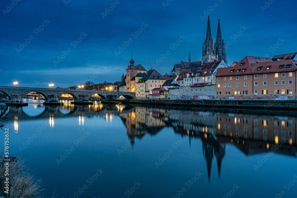 Blick über die Donau auf die Regensburger Altstatt und die steinerne Brücke zur blauen Stunde