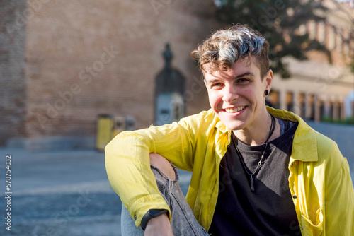 Portrait of a non binary person looking at camera while posing outdoors.