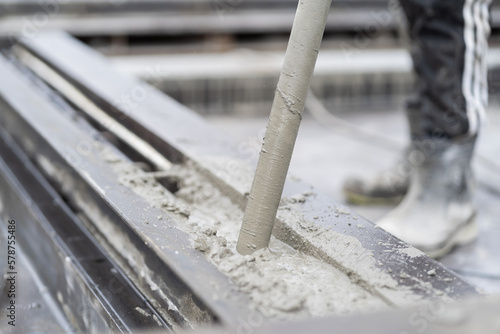 Construction technician uses concrete vibration generator during leveling concrete. Construction worker using concrete vibrator removal air bubbles for maximum strength in concrete