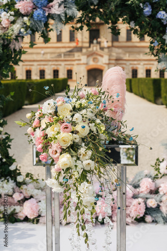 Close up of a table decorated with fresh blue and rose flowers for painting the newlyweds against the backdrop of the arch. Wedding concept  © Olga Pulchina