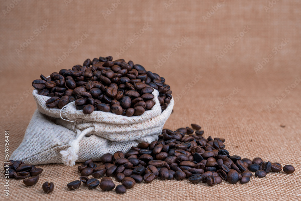 Fototapeta premium Freshly roasted coffee beans in hemp bags. There is space for ideas.