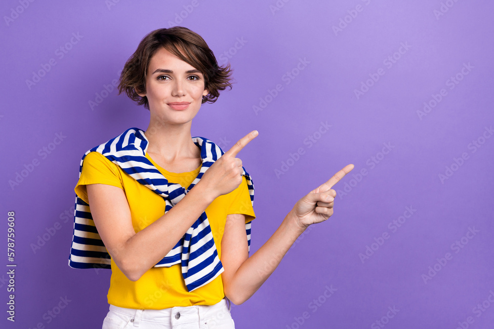 Photo of shiny adorable woman wear tied sweater smiling pointing two fingers empty space isolated purple color background Photo of shiny adorable woman wear tied sweater smiling pointing two fingers empty space isolated purple color background
