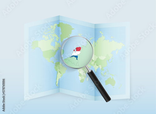 A folded world map with a magnifying lens pointing towards Netherlands. Map and flag of Italy in loupe.