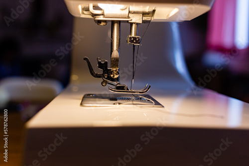 Fotobehang detalle de una maquina de coser con la aguja iluminada por su propia luz
