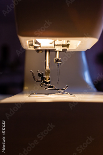 aguja de una maquina de coser iluminada con su propia luz 